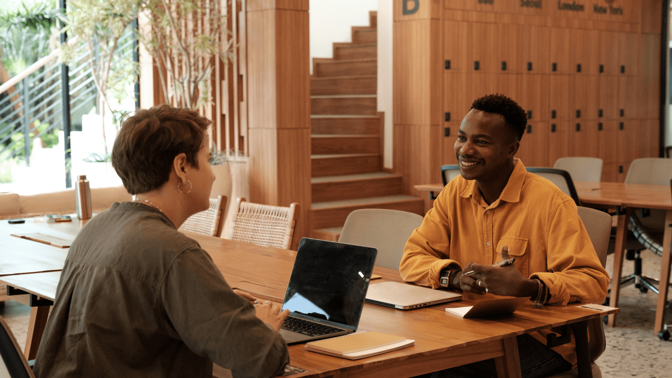 Zwei Menschen, die sich an einem Bürotisch gegenüber sitzen